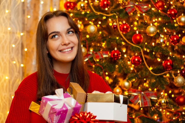 Ritratto di una giovane ragazza attraente con regali di natale