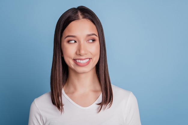 Portrait of young attractive smiling dreamy curious girl woman female look copyspace isolated on blue color background
