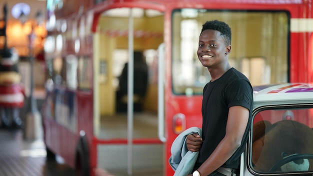 Ritratto di giovane modello di uomo afroamericano alla moda attraente che posa in abiti casual su sfondo neutro che sembra sexy con i capelli afro. in persone gioventù bellezza e concetto di moda.