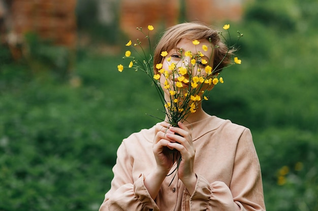 portrait of young attractive woman  holding yellow flowering plant