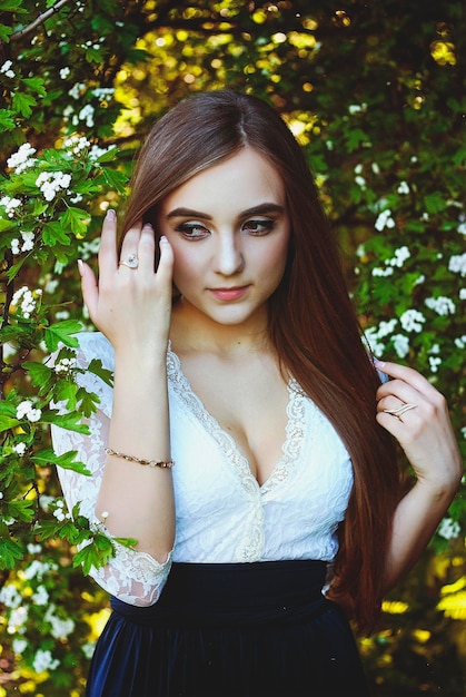 Портрет молодой привлекательной женщины в весеннем саду с букетом сирени. Весенний фон.