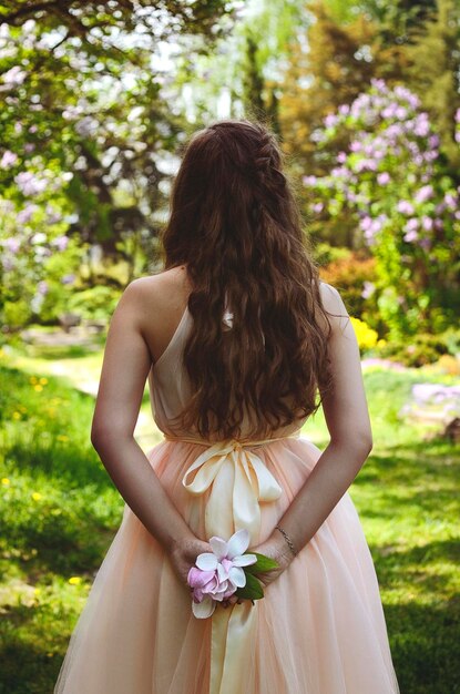 라일락 꽃다발과 함께 봄 정원에서 젊은 매력적인 여자의 초상화. 봄 배경입니다.