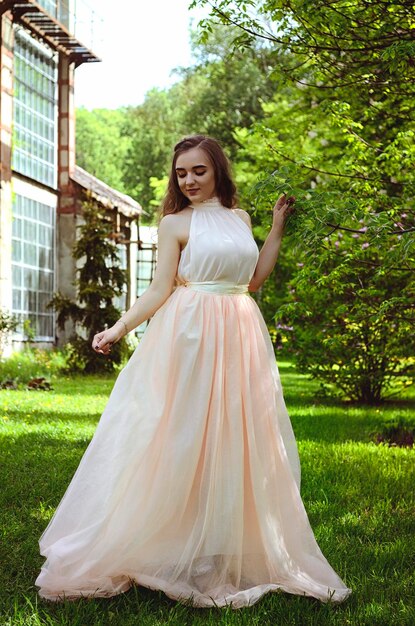 Portrait of young attractive woman in spring garden with pink blooming magnolias. Spring background