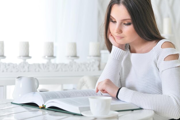 Portrait of young attractive woman with book