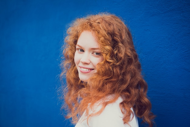 Photo portrait of young attractive woman with curly ginger hair