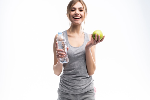 Portrait of young attractive woman with green apple and bottle