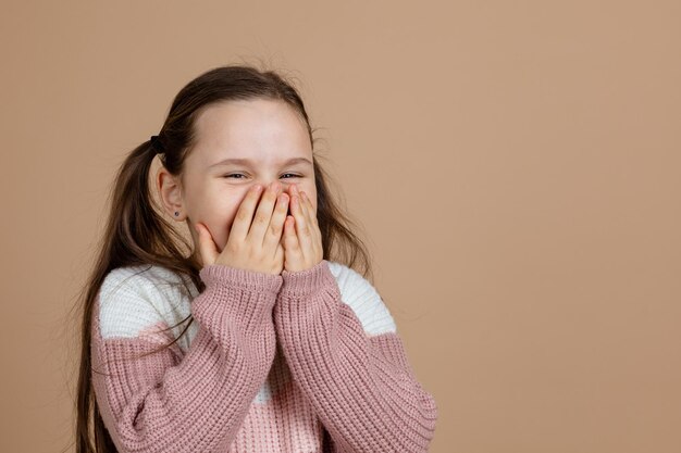 Photo portrait of young awesome girl with long dark hair in white pink sweater standing with closed eyes b