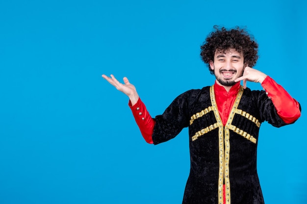 Portrait of young azeri man in traditional costume studio shot blue background ethnic dancer novruz spring