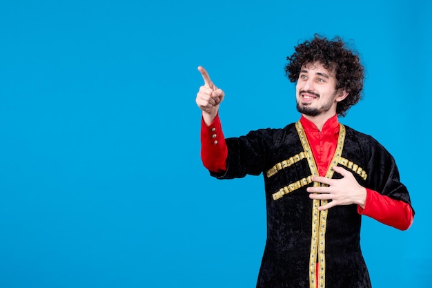 Portrait of young azeri man in traditional costume studio shot blue background spring dancer ethnic novruz color