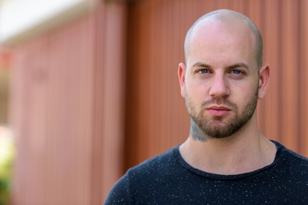 Portrait of young bald muscular man outdoors