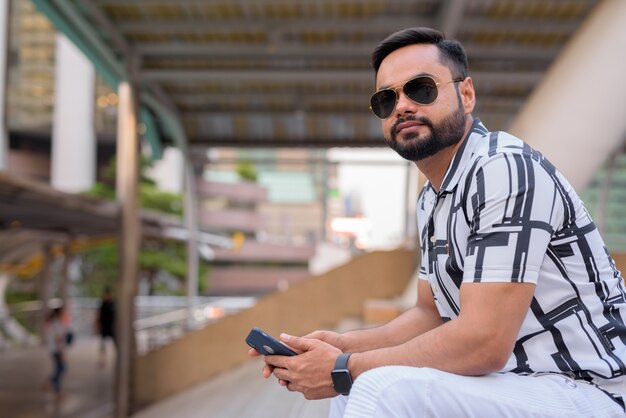 Portrait of young bearded Indian man at Chong Nonsi Station in Bangkok city