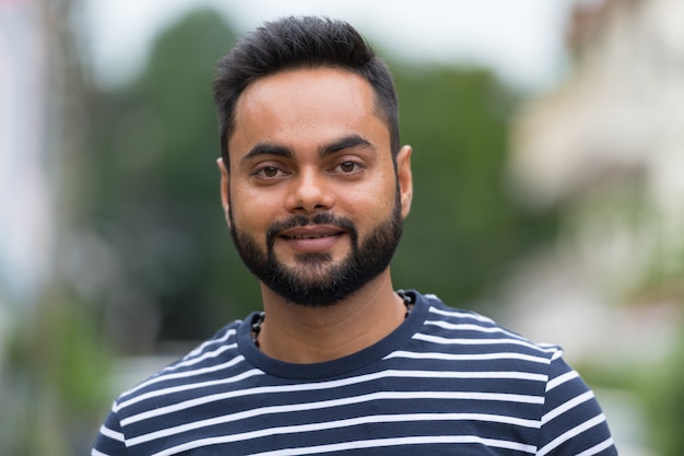 Photo portrait of young bearded indian man in the streets outdoors