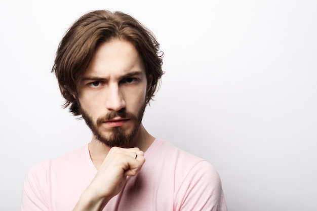 Portrait of young bearded man posing over white background casual style