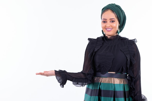 Portrait of young beautiful African Muslim woman wearing hijab isolated against white wall
