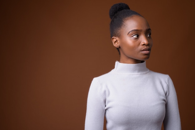 Portrait of young beautiful African Zulu businesswoman thinking