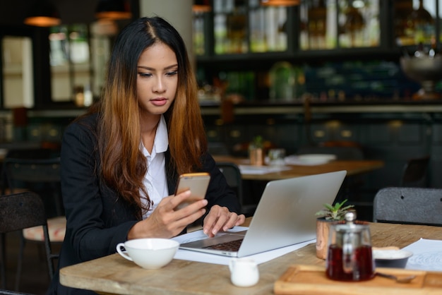 コーヒーショップで働く若い美しいアジアの実業家の肖像画