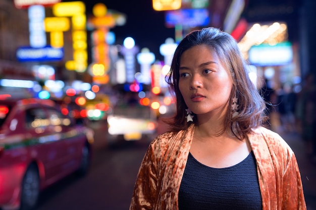 Portrait of young beautiful asian tourist woman exploring chinatown in bangkok