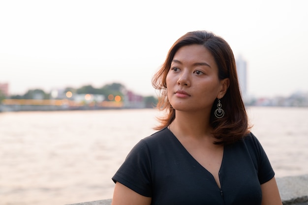 川沿いの桟橋で若い美しいアジアの観光客の女性の肖像画