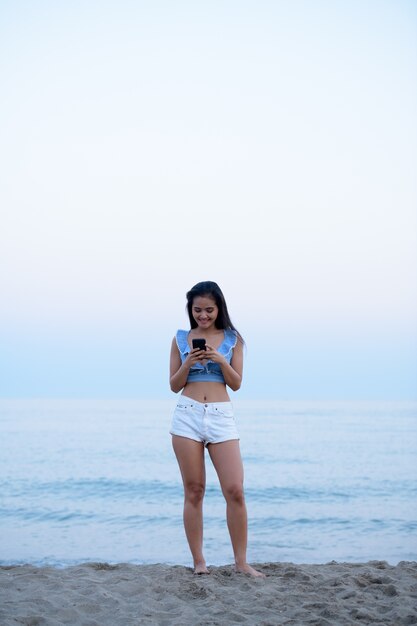 Ritratto di giovane bella donna turistica asiatica che si distende sulla spiaggia