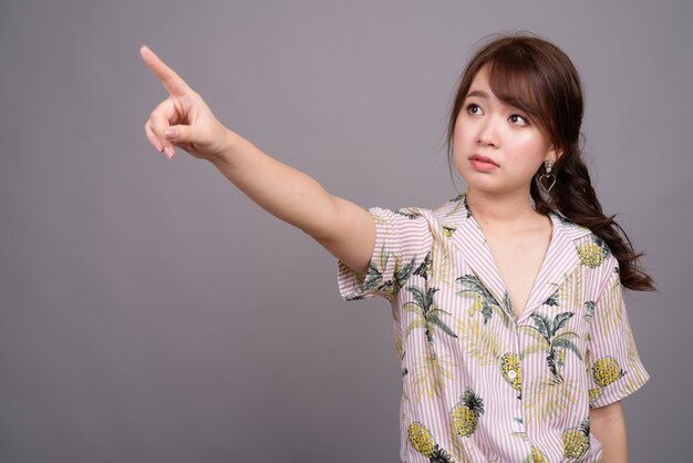 Portrait of young beautiful Asian tourist woman