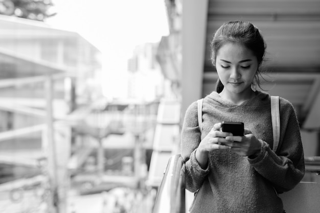 Portrait of young beautiful Asian woman around the city