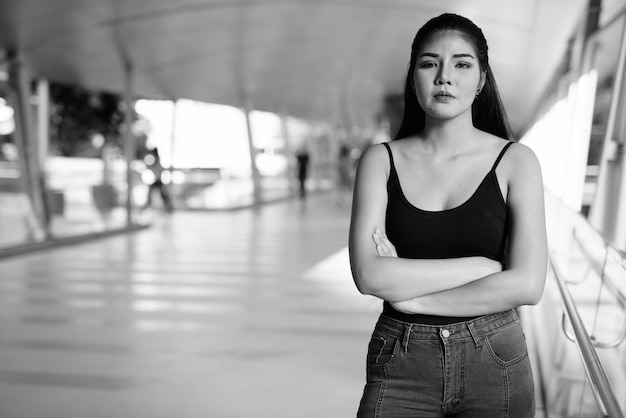 Portrait of young beautiful Asian woman exploring around the city in black and white