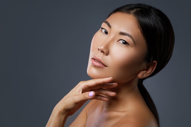 Portrait of young and beautiful asian woman model on gray wall