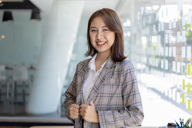 Portrait of a young beautiful Asian woman in a office room, concept image of Asian business woman, modern female executive, startup business woman, business leader woman.