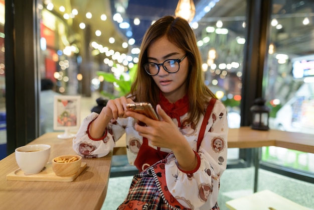 커피 숍에서 편안한 젊은 아름 다운 아시아 여자의 초상화