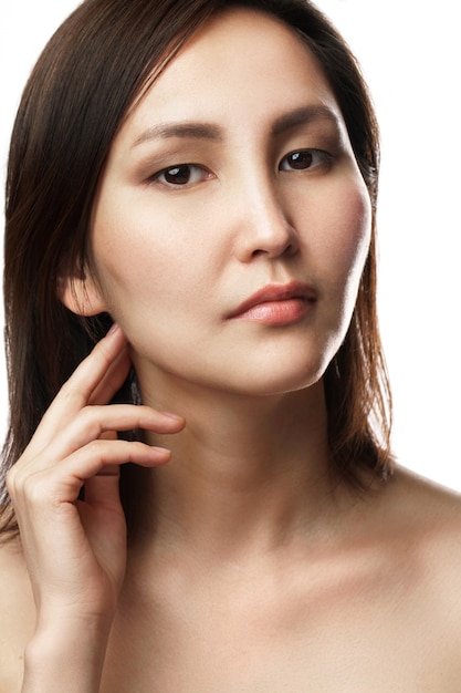 Портрет молодой и красивой азиатской женщины на белой стене