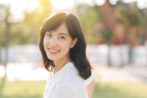 Portrait young beautiful asian woman with happy smile around outdoor park in sunny summer day