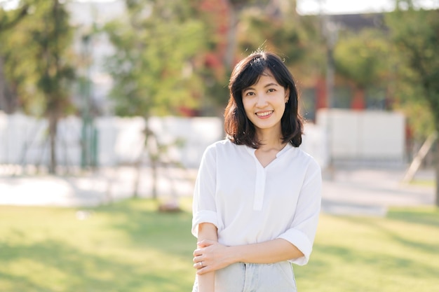 Portrait young beautiful asian woman with happy smile around outdoor park in sunny summer day