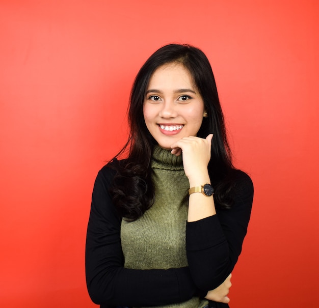 Portrait of Young beautiful asian women using black sweater with red isolated background