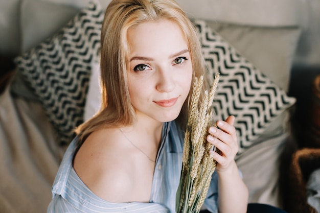 portrait of a young beautiful blonde girl in bed in the morning at home in scandinavian interior good morning lifestyle