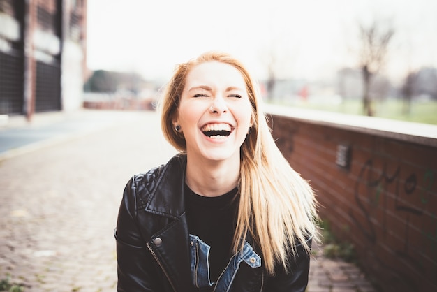 Portrait of young beautiful blonde straight hair woman in the city