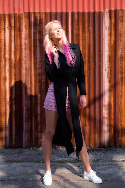 Portrait of young beautiful blonde woman exploring the city streets outdoors