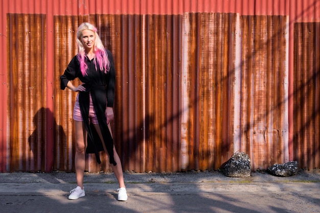 Portrait of young beautiful blonde woman exploring the city streets outdoors