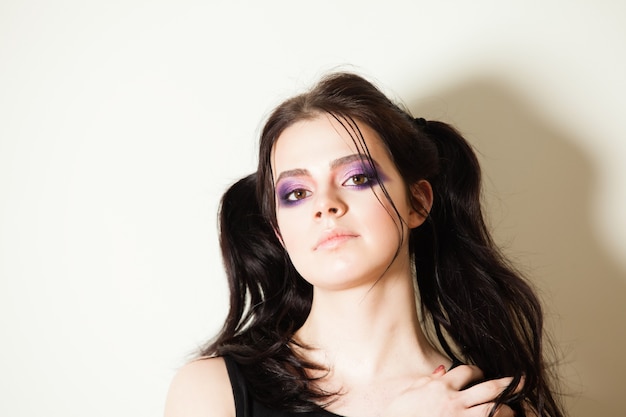 Portrait of a young beautiful brunette with a lovely fashion make-up on eyelashes