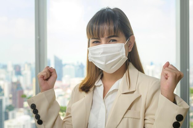 A Portrait of young beautiful Business Woman wearing a protective mask in modern office