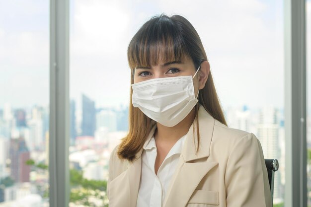 A Portrait of young beautiful Business Woman wearing a protective mask in modern office