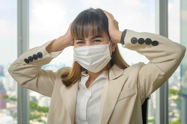 A Portrait of young beautiful Business Woman wearing a protective mask in modern office