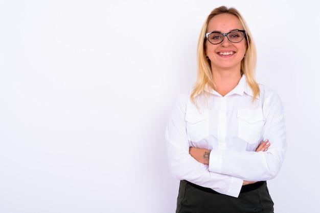 Portrait of young beautiful businesswoman with blond hair against white wall