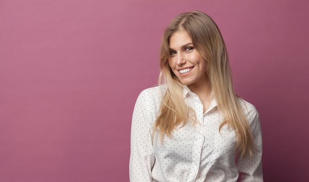 Portrait of a young beautiful caucasian woman on pink