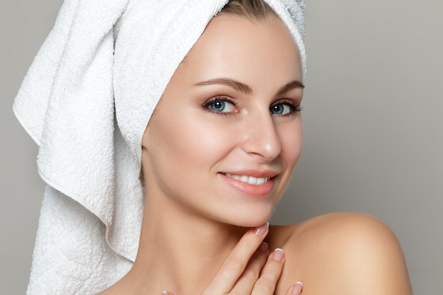 Photo portrait of young beautiful caucasian woman touching her face isolated over white background.