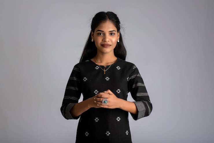 Photo portrait of a young beautiful cute cheerful girl smiling looking at the camera on gray background
