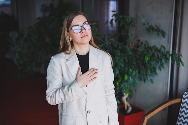 Portrait of a young beautiful fairhaired woman on her face corrective glasses Woman wearing a beige jacket