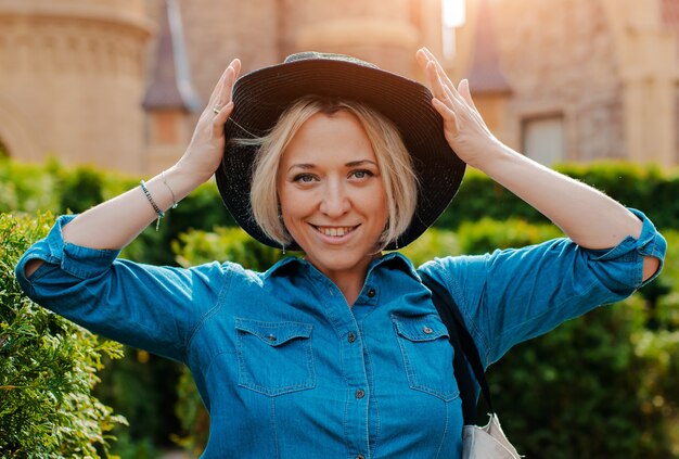 Portrait of a young beautiful fashionable happy woman posing in the street