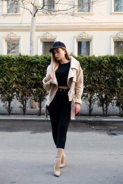 Portrait of young beautiful girl posing on street