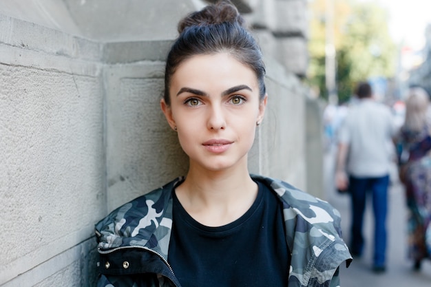 Portrait of young beautiful girl posing on street