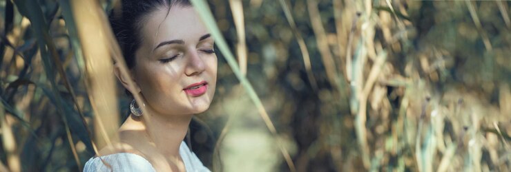 Portrait of a young beautiful girl in reeds in retro style in a light dress